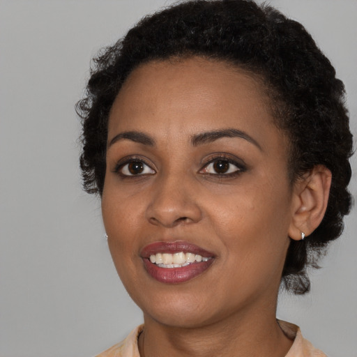 Joyful black young-adult female with short  brown hair and brown eyes