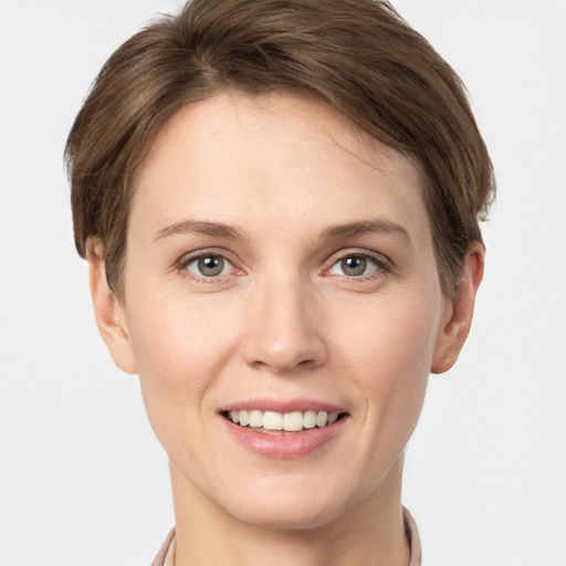 Joyful white young-adult female with short  brown hair and grey eyes