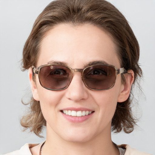 Joyful white young-adult female with medium  brown hair and blue eyes