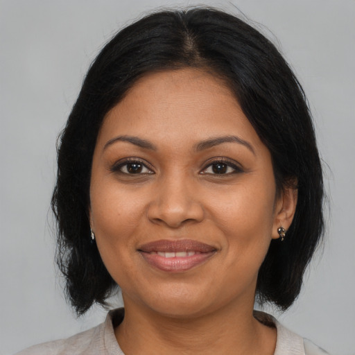 Joyful black adult female with medium  brown hair and brown eyes