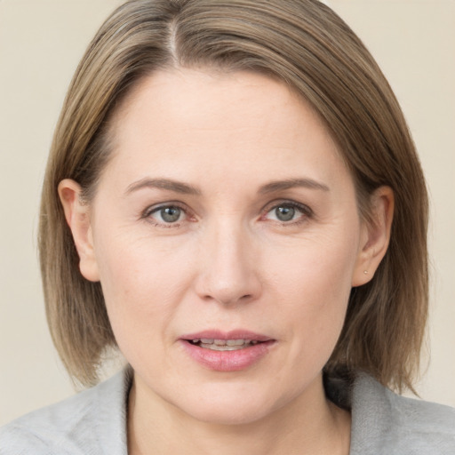 Joyful white adult female with medium  brown hair and grey eyes