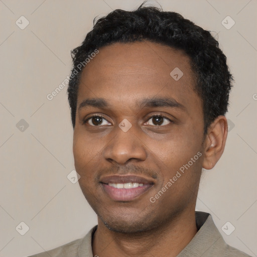 Joyful black young-adult male with short  black hair and brown eyes