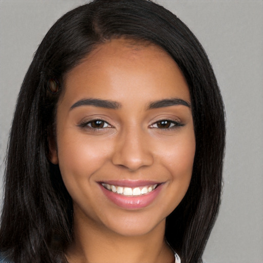 Joyful latino young-adult female with long  black hair and brown eyes