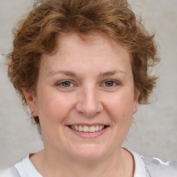 Joyful white young-adult female with medium  brown hair and blue eyes