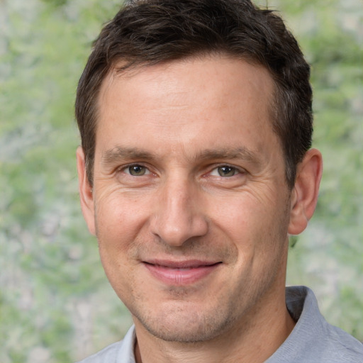 Joyful white adult male with short  brown hair and brown eyes