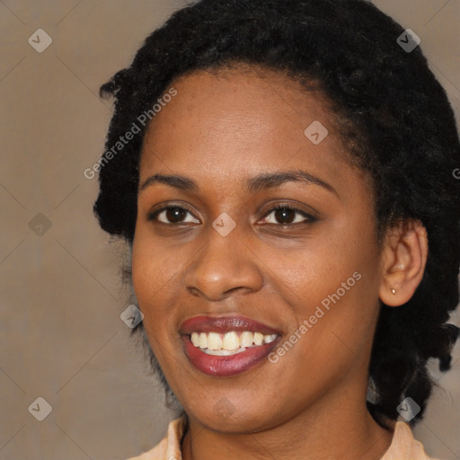 Joyful black young-adult female with long  black hair and brown eyes