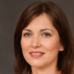 Joyful white adult female with long  brown hair and brown eyes