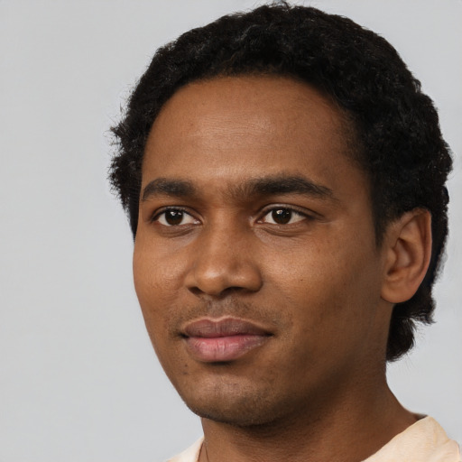 Joyful black young-adult male with short  black hair and brown eyes