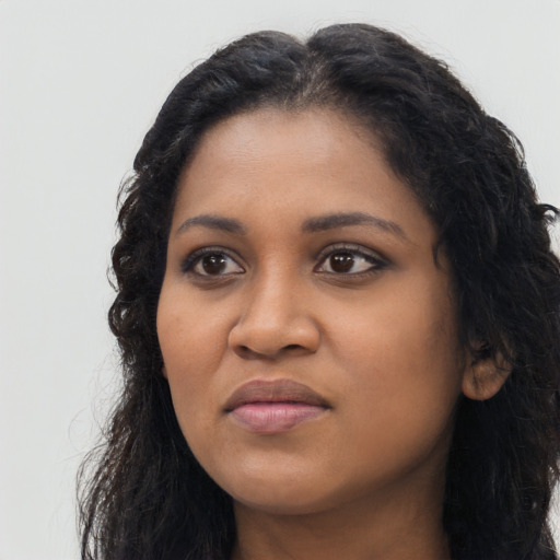 Joyful black young-adult female with long  black hair and brown eyes