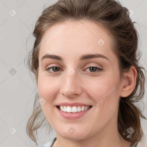 Joyful white young-adult female with medium  brown hair and grey eyes