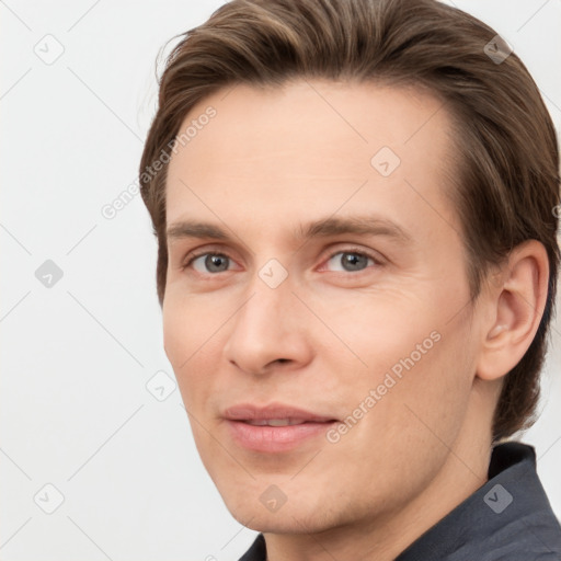 Joyful white young-adult male with short  brown hair and grey eyes