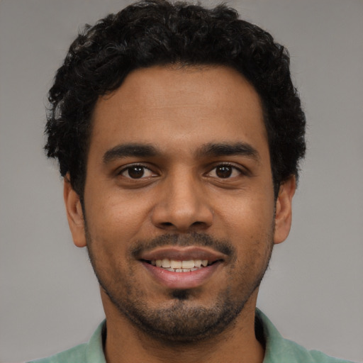 Joyful latino young-adult male with short  black hair and brown eyes
