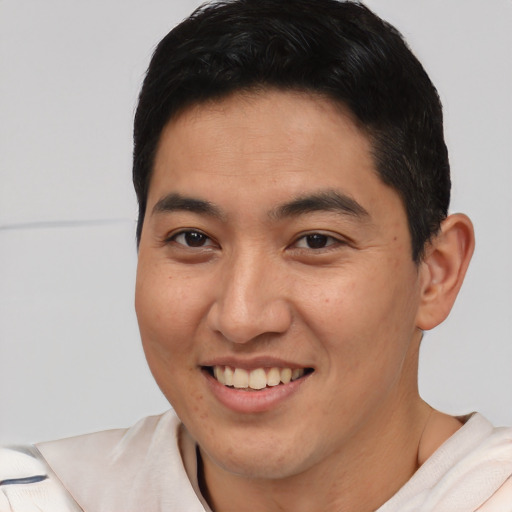 Joyful latino young-adult male with short  brown hair and brown eyes