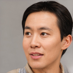 Joyful asian adult male with short  brown hair and brown eyes