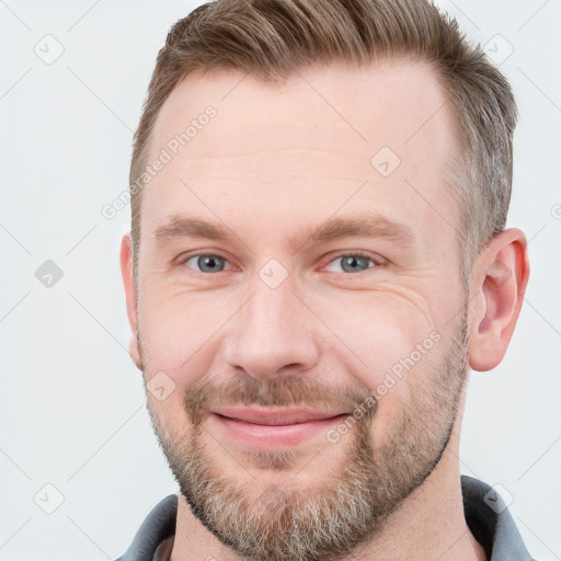 Joyful white young-adult male with short  brown hair and grey eyes