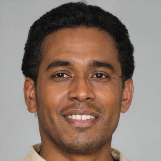 Joyful latino young-adult male with short  brown hair and brown eyes