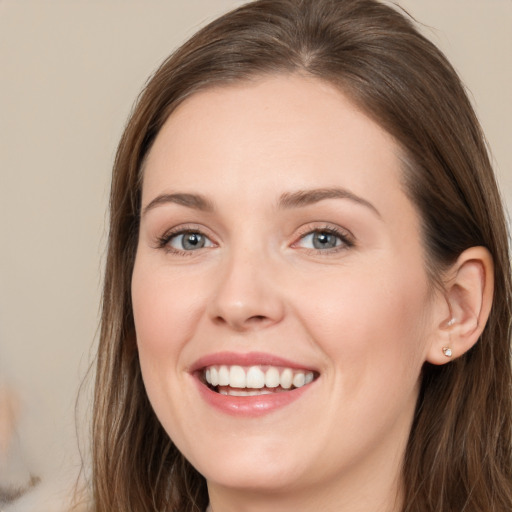 Joyful white young-adult female with long  brown hair and grey eyes