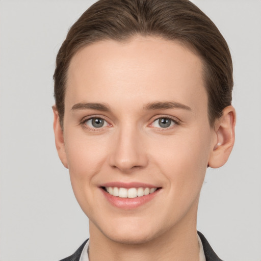 Joyful white young-adult female with short  brown hair and grey eyes