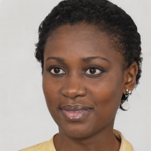 Joyful black young-adult female with short  black hair and brown eyes