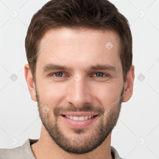 Joyful white young-adult male with short  brown hair and grey eyes