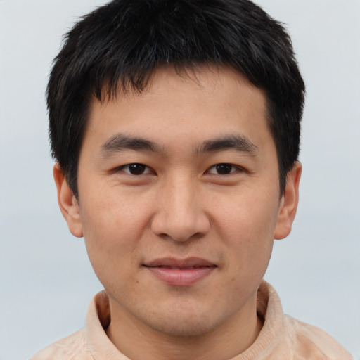 Joyful asian young-adult male with short  brown hair and brown eyes