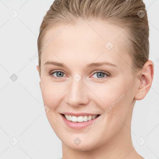 Joyful white young-adult female with short  brown hair and grey eyes