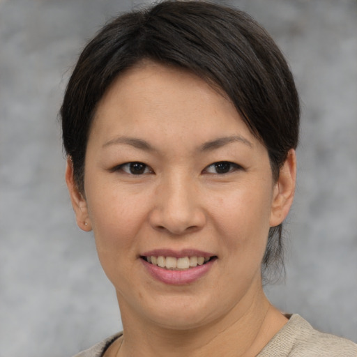 Joyful asian adult female with short  brown hair and brown eyes