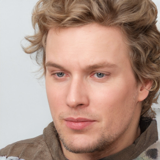 Joyful white young-adult male with short  brown hair and blue eyes