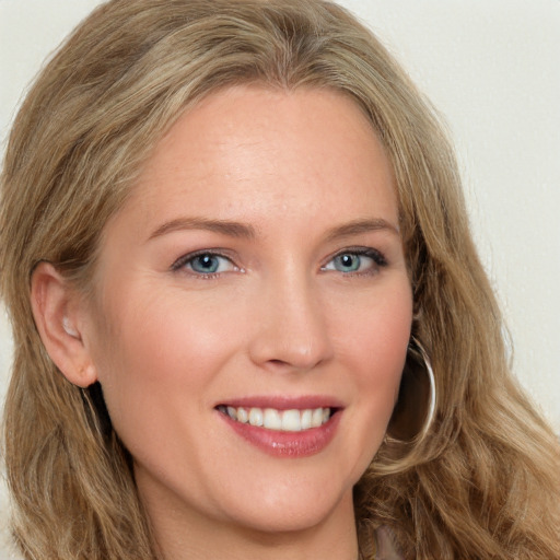 Joyful white young-adult female with long  brown hair and blue eyes