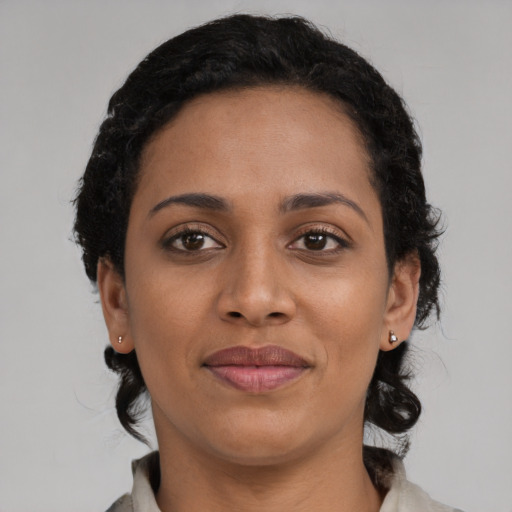 Joyful black young-adult female with medium  black hair and brown eyes