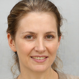 Joyful white adult female with medium  brown hair and brown eyes