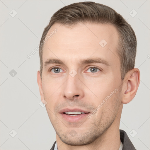 Joyful white young-adult male with short  brown hair and grey eyes