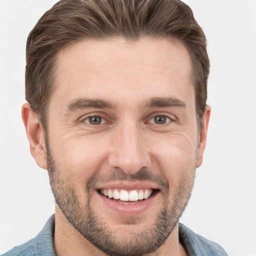 Joyful white young-adult male with short  brown hair and grey eyes