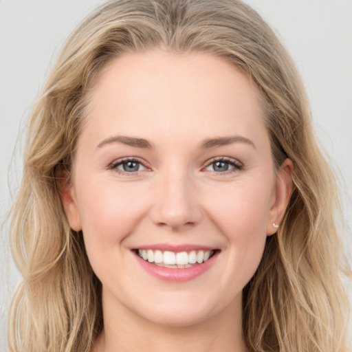 Joyful white young-adult female with long  brown hair and blue eyes