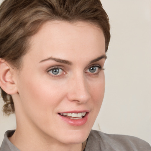 Joyful white young-adult female with short  brown hair and blue eyes