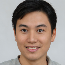 Joyful asian young-adult male with short  brown hair and brown eyes