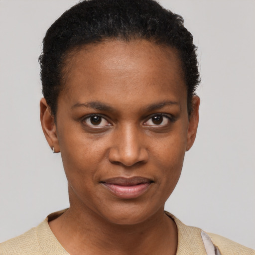 Joyful black young-adult female with short  black hair and brown eyes