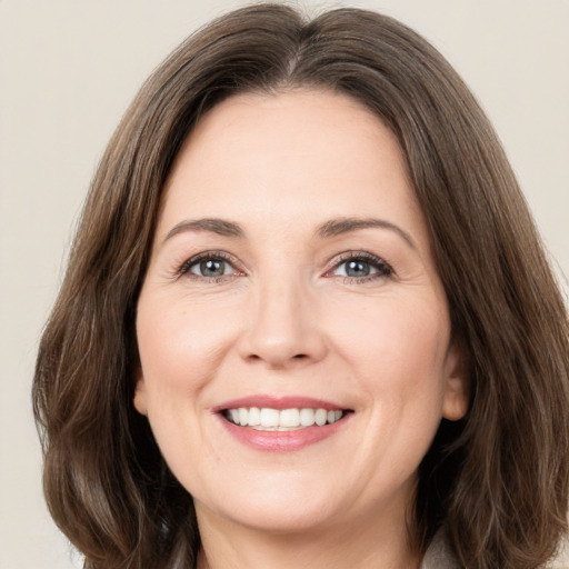 Joyful white adult female with medium  brown hair and brown eyes