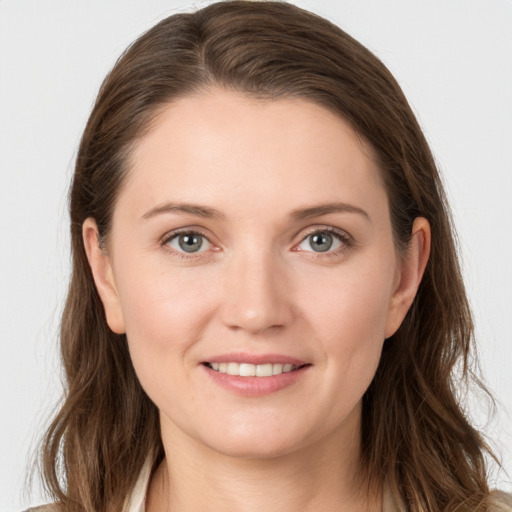 Joyful white young-adult female with long  brown hair and grey eyes