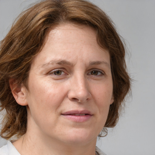 Joyful white adult female with medium  brown hair and green eyes