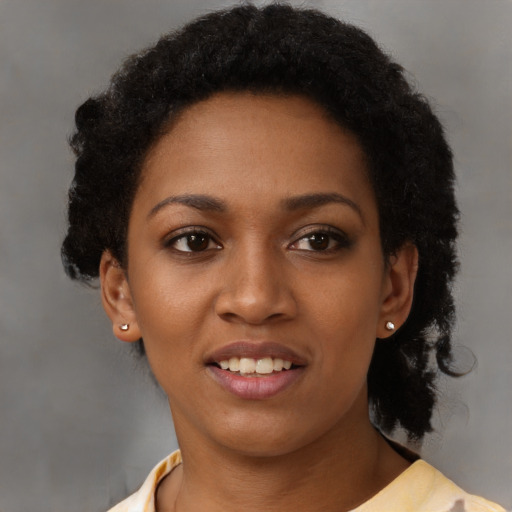 Joyful black young-adult female with short  black hair and brown eyes