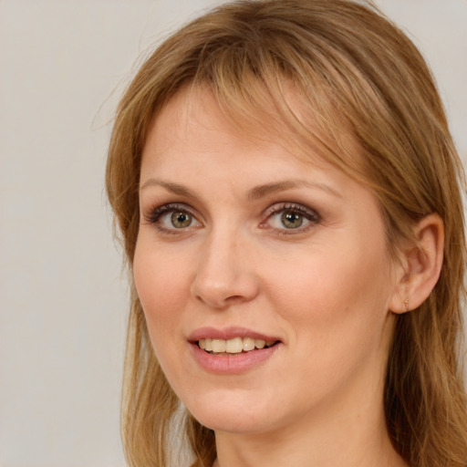 Joyful white young-adult female with long  brown hair and blue eyes