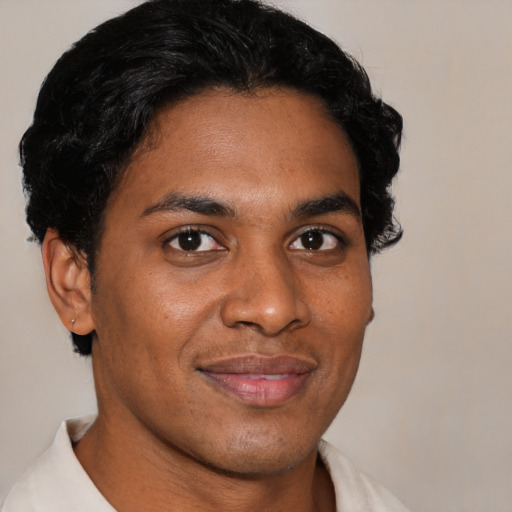 Joyful black young-adult male with short  black hair and brown eyes