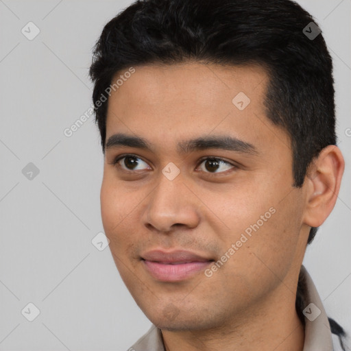 Joyful latino young-adult male with short  black hair and brown eyes