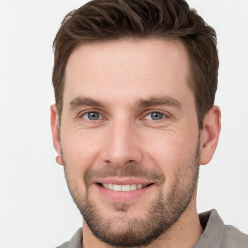 Joyful white young-adult male with short  brown hair and grey eyes