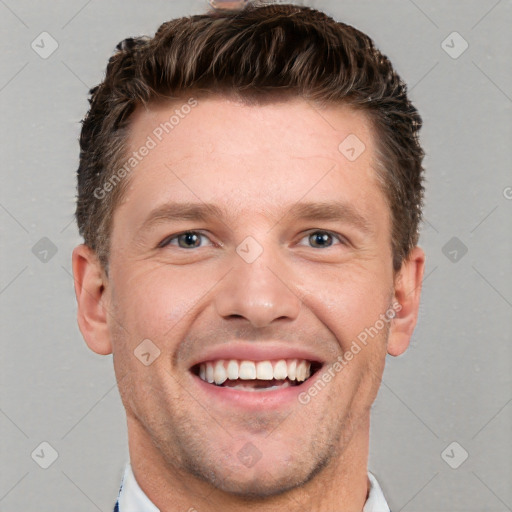 Joyful white young-adult male with short  brown hair and grey eyes