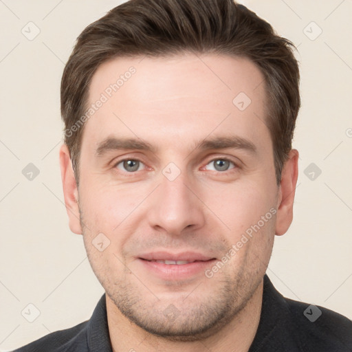 Joyful white young-adult male with short  brown hair and grey eyes