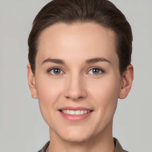 Joyful white young-adult female with short  brown hair and grey eyes