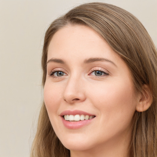 Joyful white young-adult female with long  brown hair and grey eyes