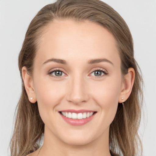 Joyful white young-adult female with long  brown hair and grey eyes